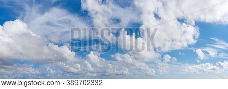 Fluffy Cumulus Clouds, Translucent Cirrus And Stratus Clouds Float Slowly Across The Bright Blue Sky