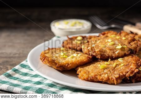 Traditional Jewish Latkes Or Potato Pancakes On Wooden Table