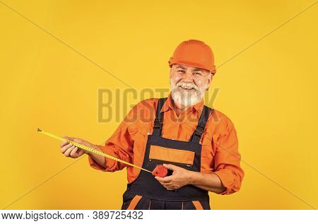 Senior Builder Use Tape-line For Measure. Measurement. Engineer Size Measuring. Construction Man Hol