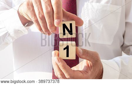Number One Concept, N1 Inscription On Wooden Cubes In Businessman Hands.