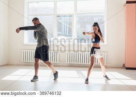 In A Spacious Loft, A Male Trainer And His Female Mentee Conduct A Boxing Training Session