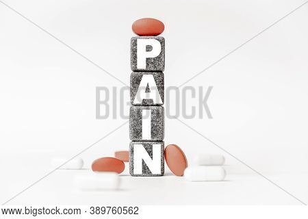 A Group Of White And Red Pills And Cubes With The Word Pain On Them, White Background. Concept Careh