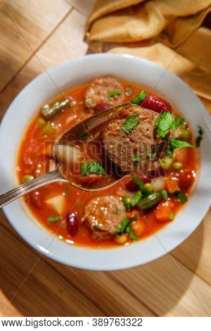 Hearty Italian Minestrone Soup With Sliced Sausage And Vegetables