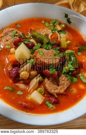 Hearty Italian Minestrone Soup With Sliced Sausage And Vegetables