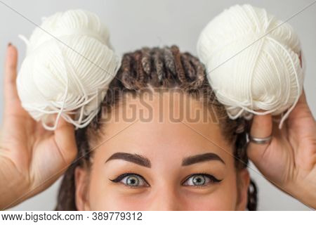 A Beautiful Young Girl Knitter Smiles And Holds Skeins Of White Yarn In Her Hands, Applying Them To 