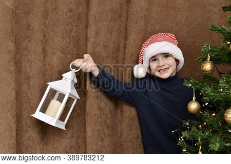 The Boy Smiles, With A Fallen Tooth, Peeking Out From The Charged Christmas Tree, With A Lantern In 