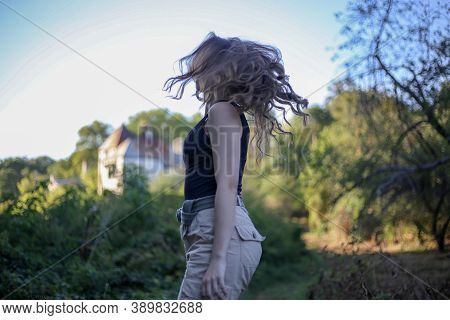 Young Woman With Curly Hair In The Park
