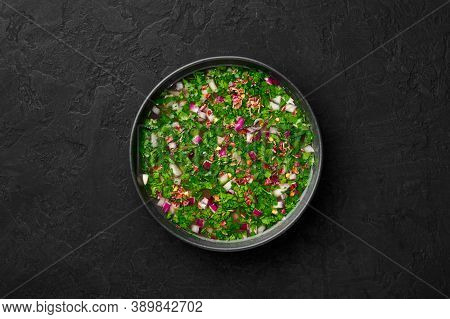 Pachi Pulusu In Black Bowl On Dark Slate Table Top. Raw Tamarind Rasam Is Indian Cuisine Soup Dish.