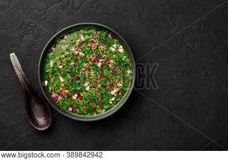 Pachi Pulusu In Black Bowl On Dark Slate Table Top. Raw Tamarind Rasam Is Indian Cuisine Soup Dish.