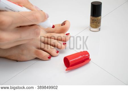 Girl Makes A Pedicure. Girl Paints Her Toenails. Woman Makes New Pedicure.the Process Of Applying Pe