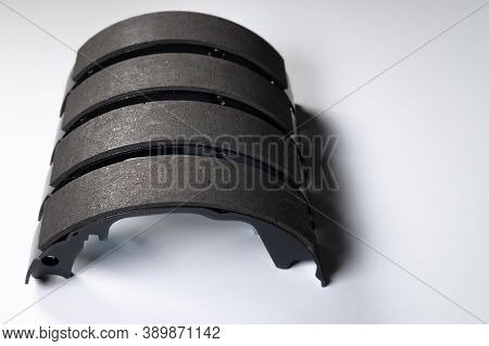 New Set Of Four Brake Pads For Drum Brakes On A Gray Background