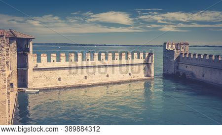 Sirmione, Italy, September 11, 2019: Small Fortified Harbor With Turquoise Water, Scaligero Castle C