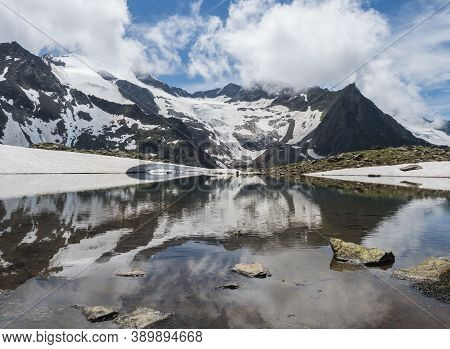 Beautiful Glacial Lake With Springs From Melting Ice Glacier With Sharp Snow-capped Mountain Peaks R