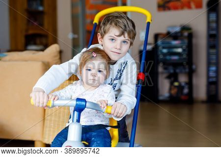 Little Kid Boy Pushing Bycicle Or Tricycle With Cute Baby Sister. Toddler Girl And Brother Playing T