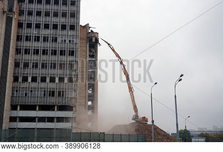 Moscow / Russia - October 13 2020: A Very Long Boom Excavator Destroys A High-rise Building. Demolit