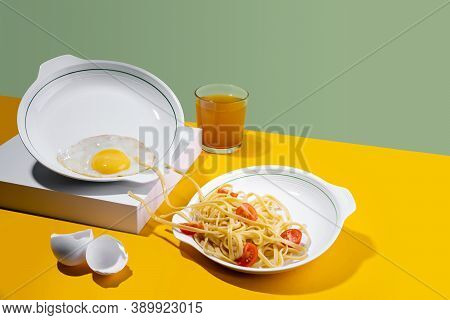 Concept Pastafarianism. Monster Noodles Spagetti In A White Plate Attacking Fried Eggs For Breakfast