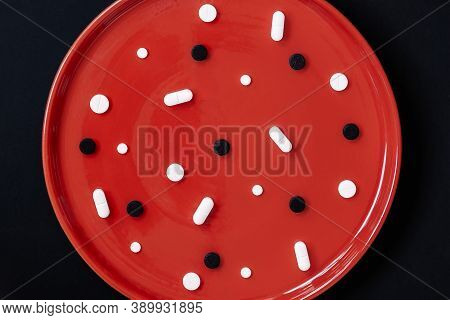 Red Plate Full Of White And Black Pills, Bright Backgrund, Concept Of Correct Use Of Medicines, Diff
