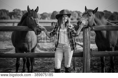 American Woman On A Horse Farm. Portrait Of Girl In Cowboy Hat With A Horses. Hippotherapy At Nature