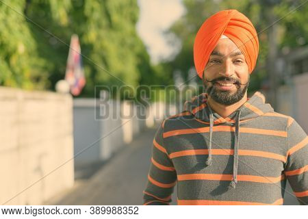 Young Handsome Indian Sikh Man Wearing Turban In The Streets Outdoors