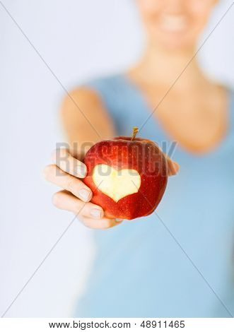 comida sana y estilo de vida - mano de mujer sosteniendo una manzana roja con forma de corazón