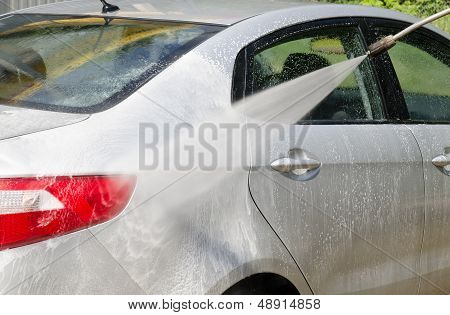 Manual Car Washing Cleaning With Foam And Pressured Water At Service Station