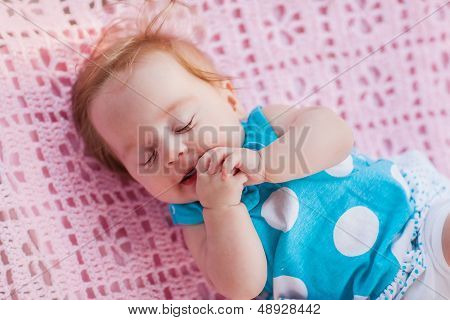 Sweet Little Baby Sleeping. She In Blue Dress With White Polka Dots.
