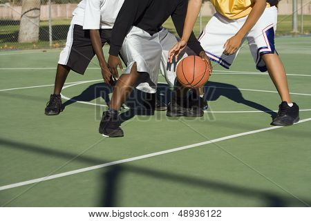Üç adam basketbol oynarken düşük bölümü