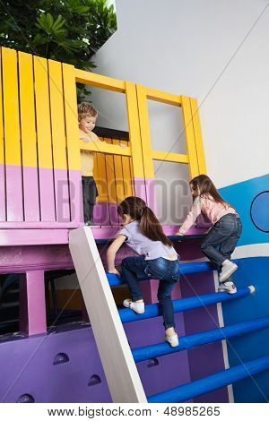 Po celé délce holčičky lezení playhouse žebříku při pohledu na ně chlapec