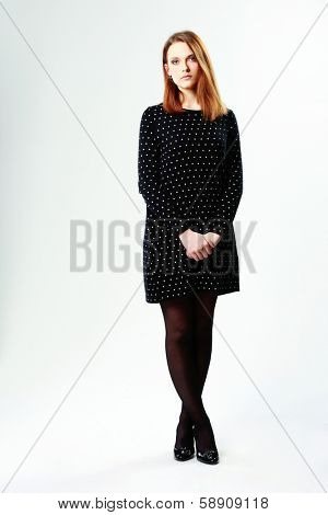 Full-length portrait of a young beautiful woman in formal dress on white background