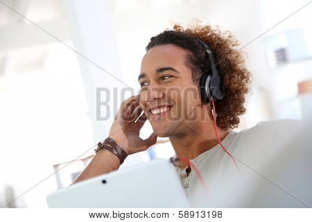 Smiling man listening to music with tablet