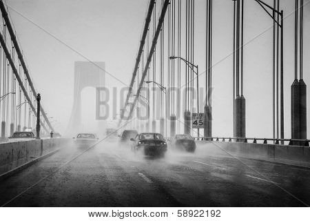 Cars driving in heavy rain on suspension bridge