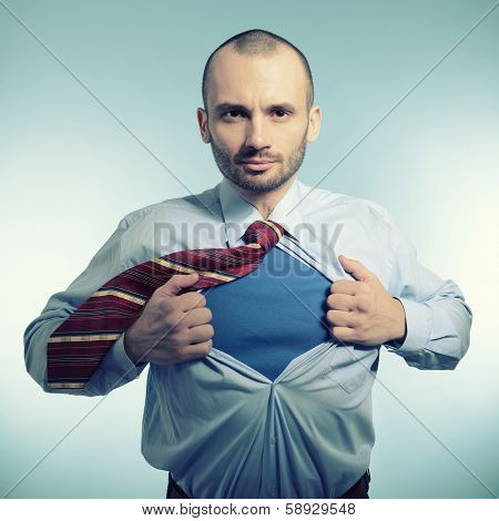 Super hero. Business manopening his shirt like a superhero, over blue background