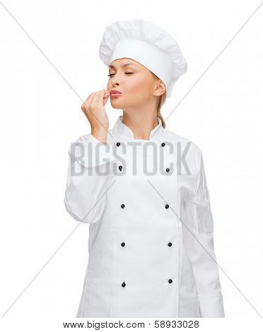 cooking, gesture and food concept - smiling female chef showing delicious gesture