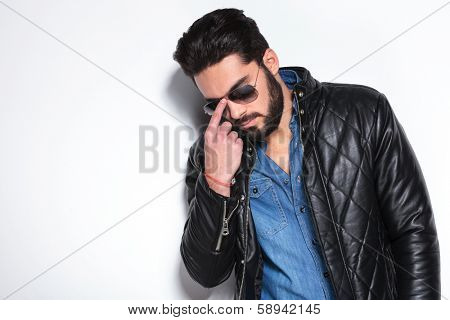 fashion man pushing his sunglasses back on , studio picture
