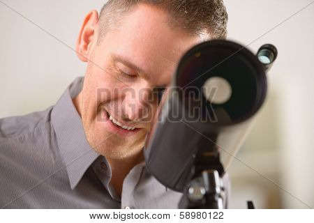 Man looking skyward through astronomical telescope