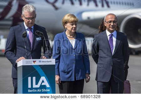 BERLIN, GERMANY - MAY 20, 2014: German Chancellor Angela Merkel (C) and Turkish Minister of transport Lutfi Elvan (R) open up the International aviation and space exhibition ILA.