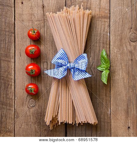 Pasta, Tomatoes And Basil On Wooden Background