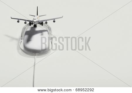 Jumbo jet on apple macintosh computer mouse, digital composite