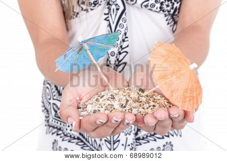 girl's hands carrying sand with two mini umrellas on it