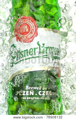 Pilsner Urquell pale lager beer in splashed water.