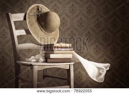 Old Books On A Chair With Straw Hat