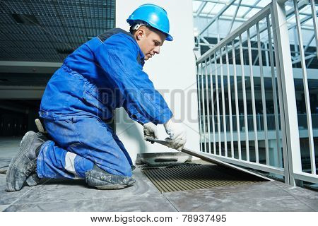 industrial tiler builder worker installing floor tile at repair renovation work
