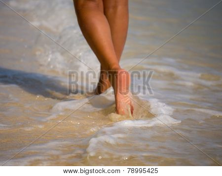 Woman walking on the sandy beach - Selective focus