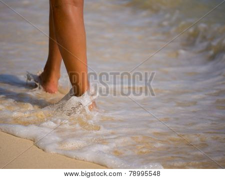 Woman walking on the sandy beach - Selective focus