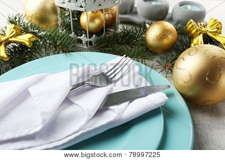 Christmas table setting in blue, golden and whitec olors on grey tablecloth background