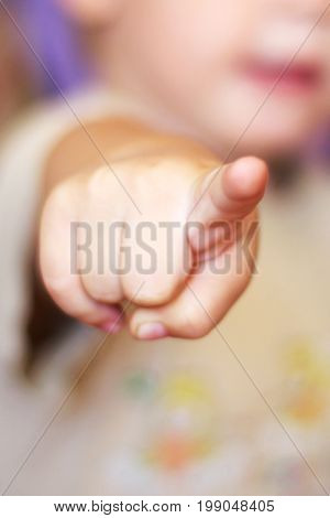Hand pointing at observer, Little child in the background