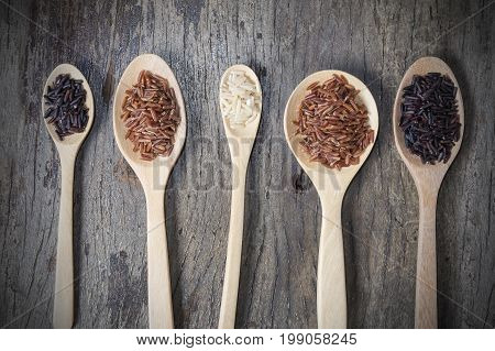 Healthy Organic Rice: Riceberry Rice and Brown Rice on wood background