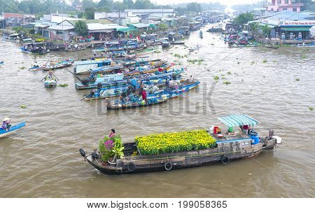 Soc Trang, Vietnam - January 21, 2017: Boats flower exchange trade on the river in the morning with the boat loaded with daisies which only sell flowers on Tet new floating market Soc Trang, Vietnam