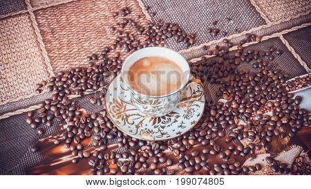 Cup of morning fresh fragrant coffee on a table with grains