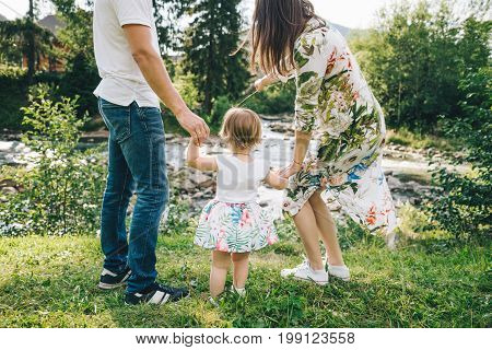 happy family play with daughter near the river in mountains, old bridge on backgeound